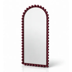 An arched wall mirror with a dark burgundy beaded frame, shown on a clean white background with a soft reflection underneath.