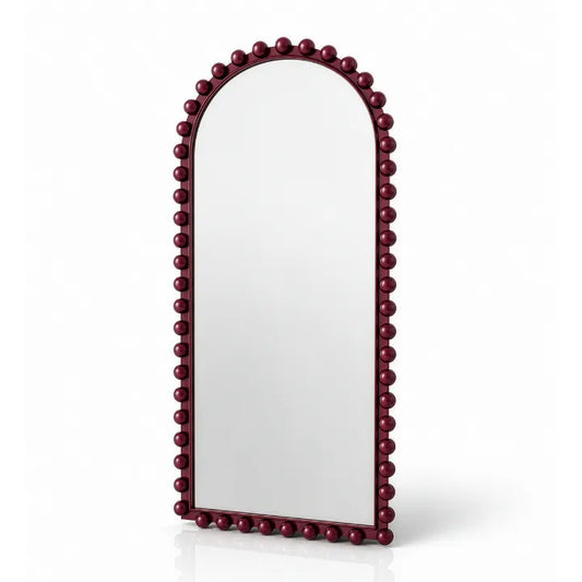 An arched wall mirror with a dark burgundy beaded frame, shown on a clean white background with a soft reflection underneath.