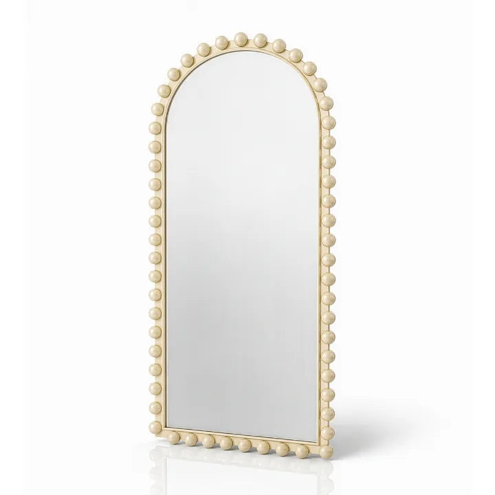 An arched wall mirror with a decorative frame adorned with small round beads, finished in a warm cream or light beige tone, shown on a clean white background.